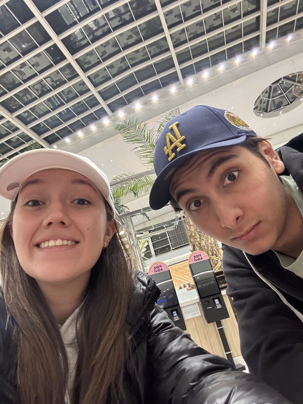 Valeria y Abraham con gorras en un centro comercial
